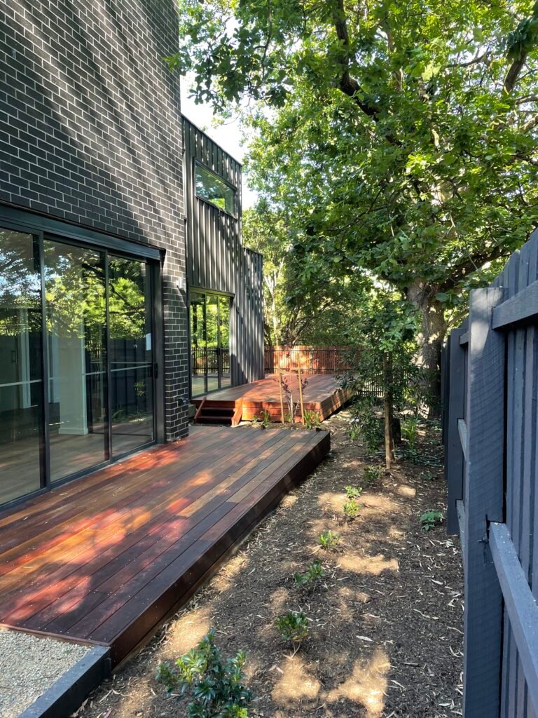 Modern black brick home with timber deck by PJ Thomas Homes
